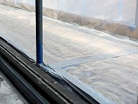 The edges of an enclosure prepared to remove asbestos, polythene sealed with cloth tape